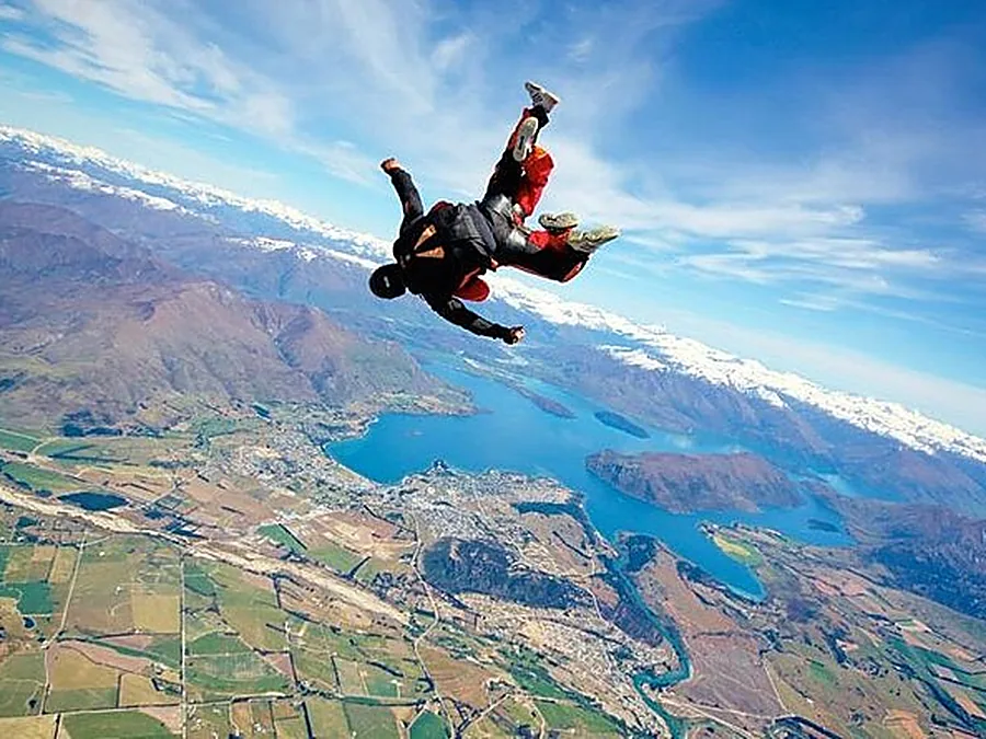 A tandem pair in freefall over lakes and farmland