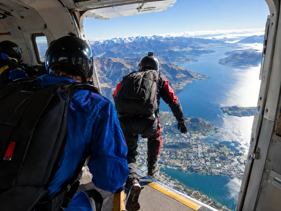 A jumper at the open door of a jump plane above Lake Wakatipu